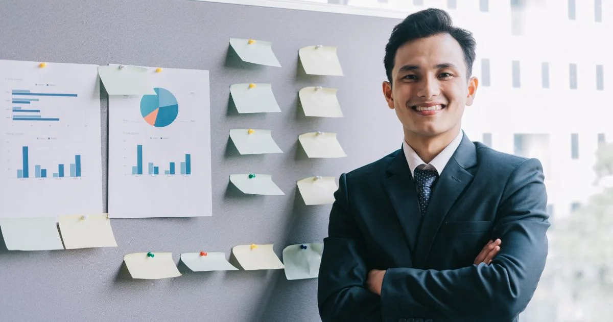 Business professional standing in front of employee benefits charts